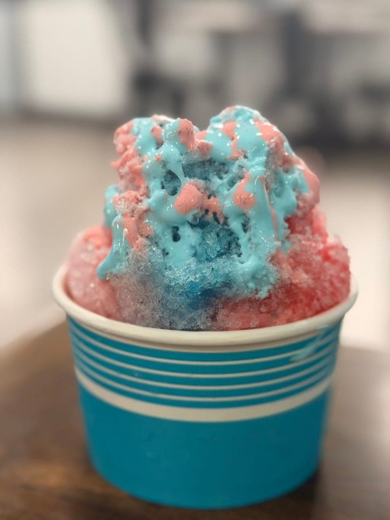 The 7P specialty snowball, with pink and blue shaved ice with sour blue and cherry marshmallow in a blue cup