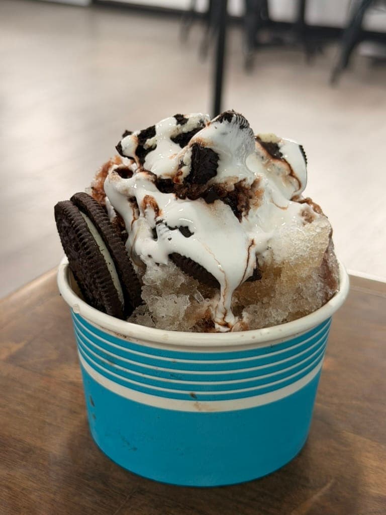 The Midnight Snack specialty snowball topped with marshmallow, chocolate drizzle, and Oreo cookies